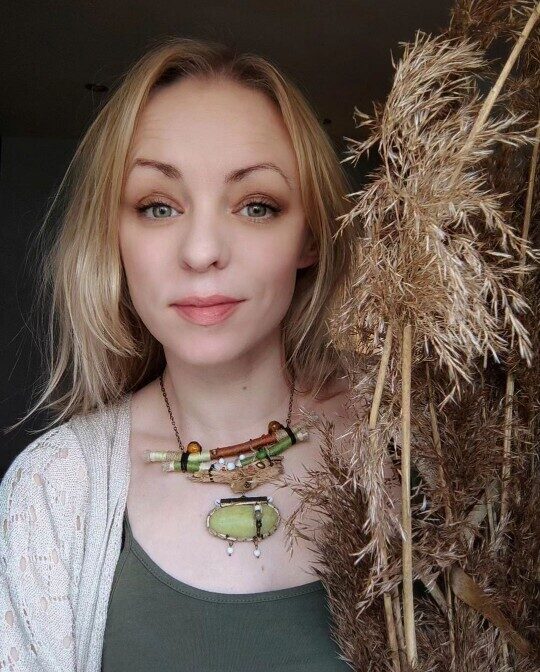 Agija Rezcova, nature-inspired artist from Latvia, wearing handmade forest jewelry created from natural materials.