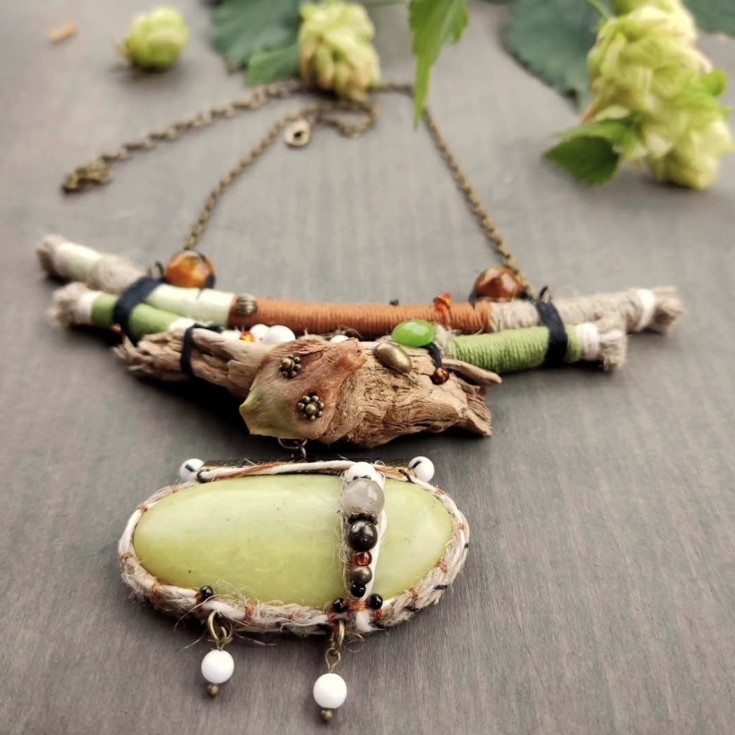 Handmade nature-inspired jewelry with forest and seaside materials — driftwood, green stone, and natural beads.