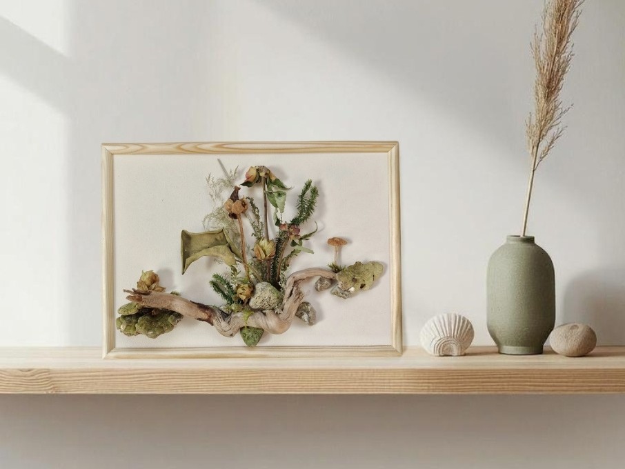 Nature-based wall artwork made from driftwood, stones, moss, fungi and dried plants arranged on an A4 board with a natural wooden frame